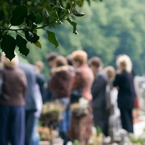 Bestattung mit trauernden Menschen am Grab